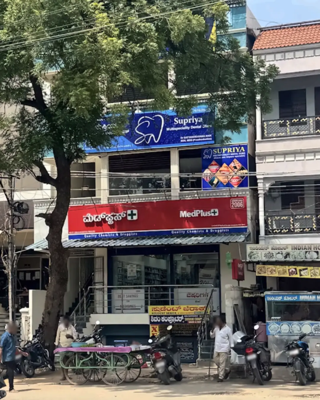 The clinic's building at Vidhya Nagar Circle: the blue Supriya Multispeciality Dental Clinic signboard on the 1st floor, above the red MedPlus pharmacy sign