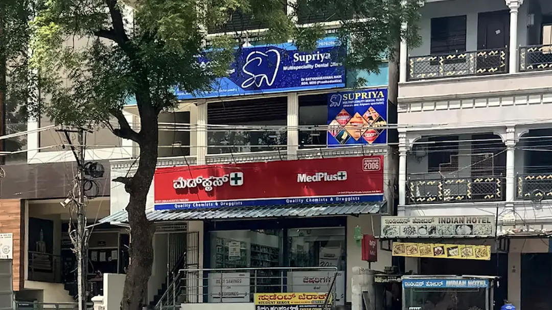 Street view of the building at Vidhya Nagar Circle, with the blue Supriya Multispeciality Dental Clinic signboard above the MedPlus pharmacy