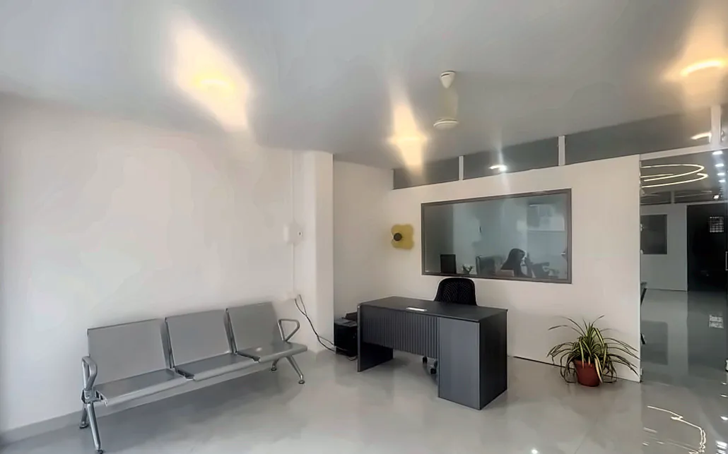 Waiting area with steel bench seating and the reception desk at Supriya Multispeciality Dental Clinic