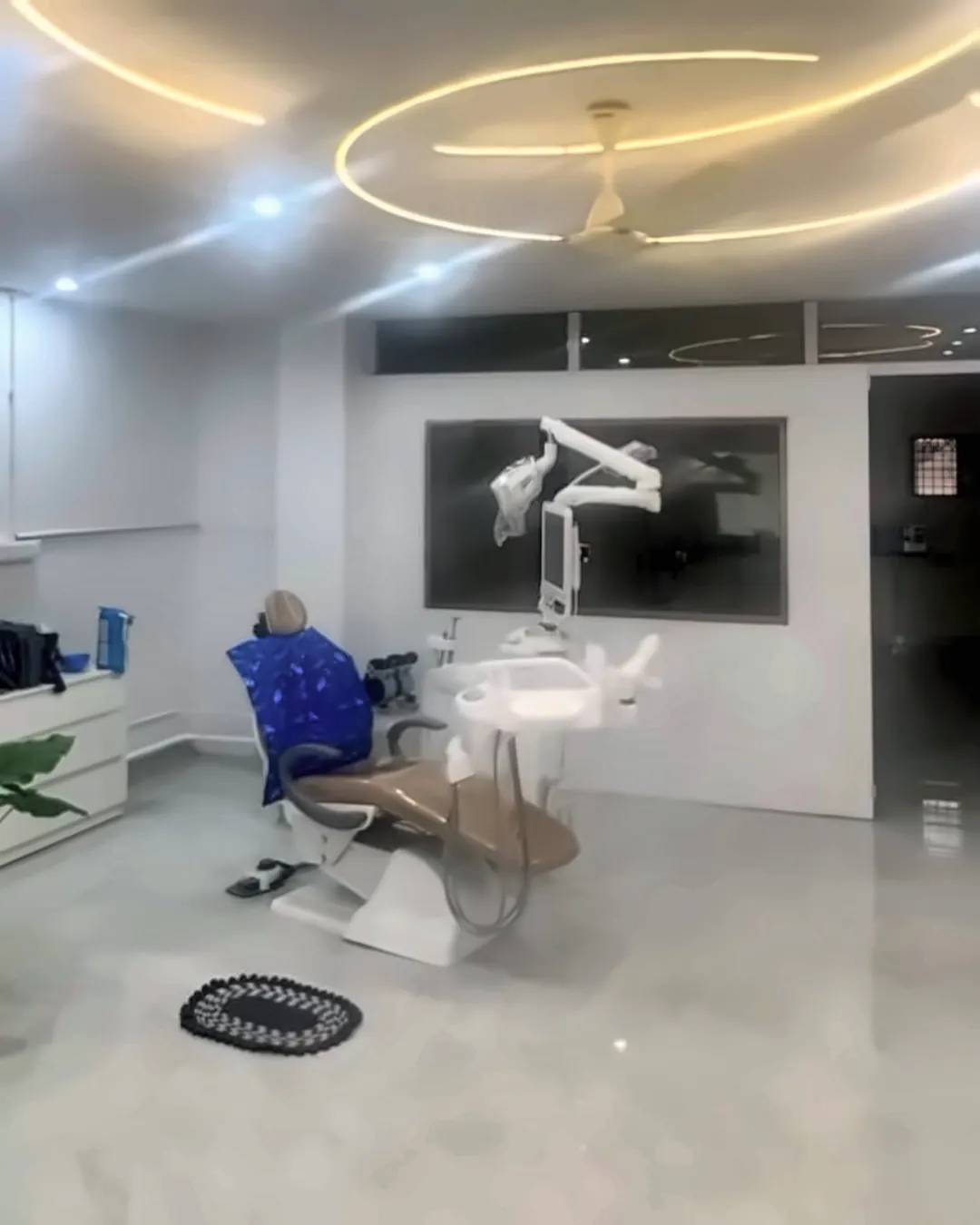 Treatment room at Supriya Multispeciality Dental Clinic, with the dental chair beneath circular ceiling lights